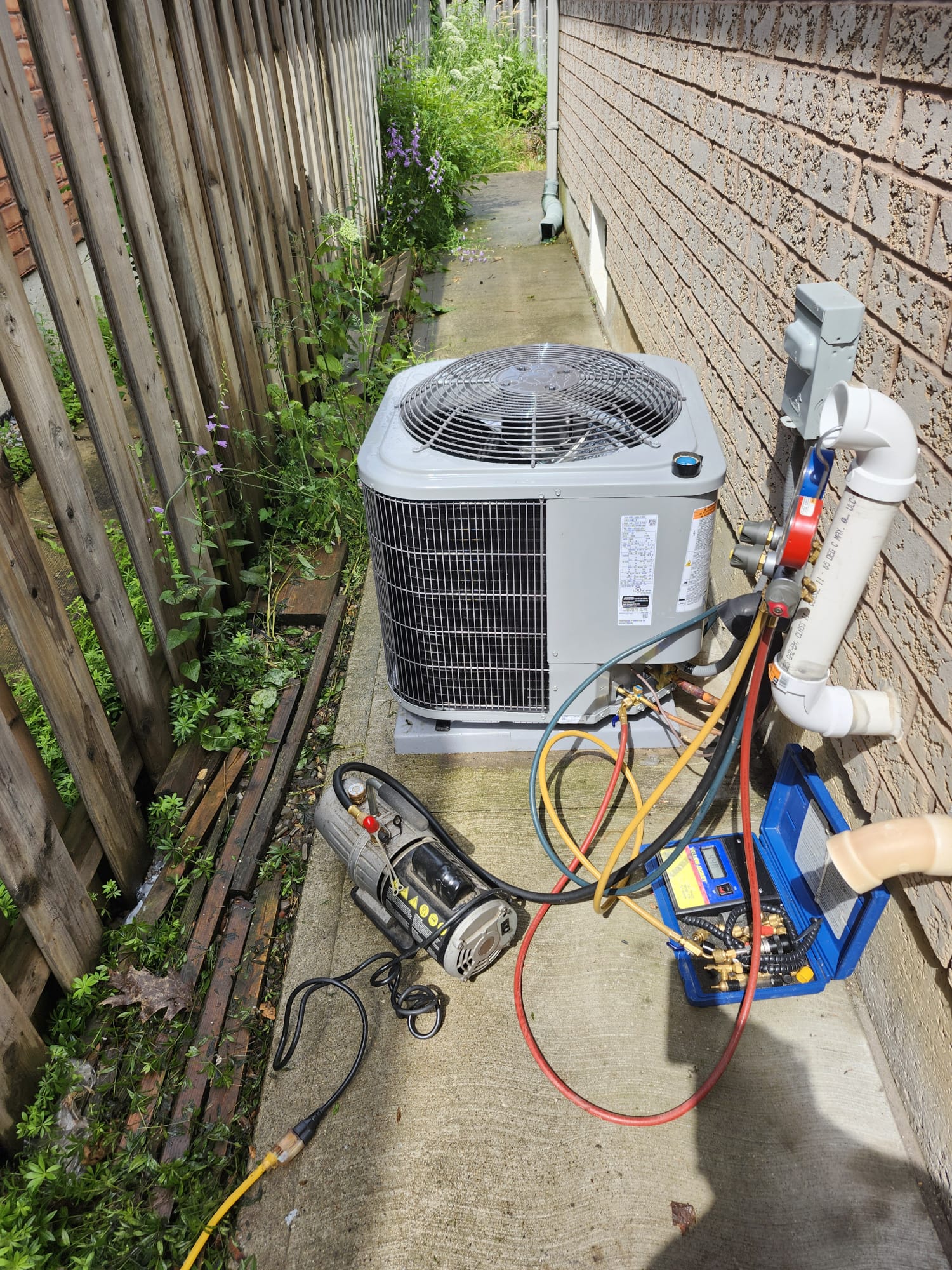 Air conditioner being evacuated and recharged with gauges